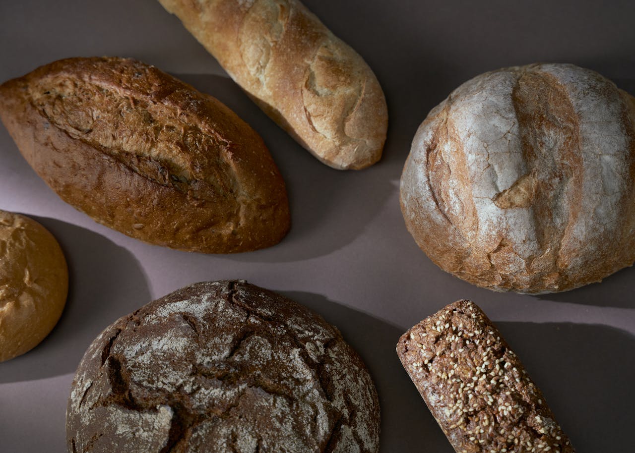 A selection of artisan breads displayed on a flat surface, showcasing diverse textures and styles.